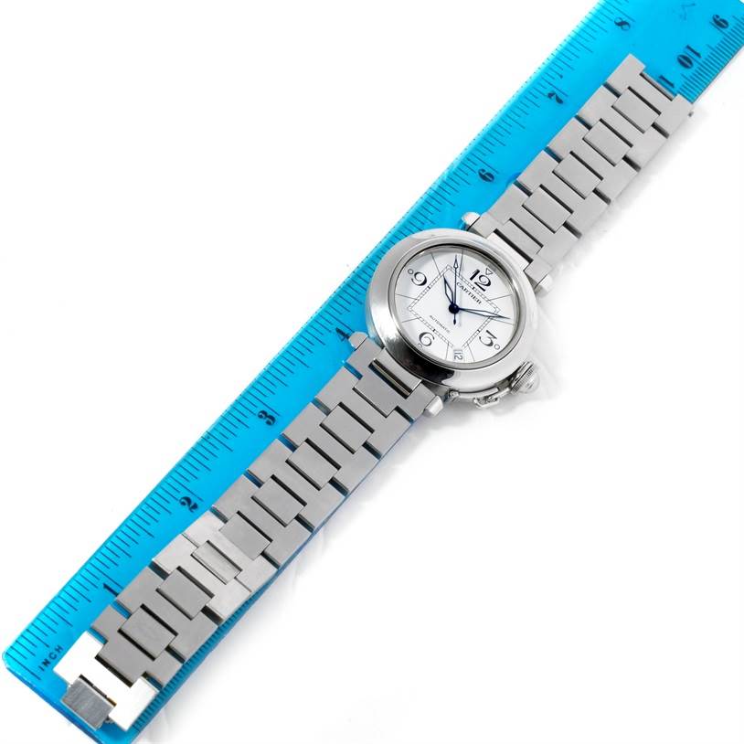 The image shows a full view of the Cartier Pasha W31074M7 Women's Stainless Steel White Dial W31074M7 Women's Stainless Steel White Dial watch, including its silver band and face, placed next to a ruler for size reference.