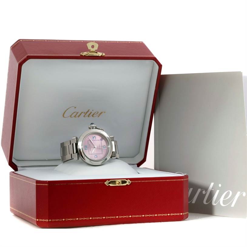 This image shows a Cartier Pasha W3108199 Women's Stainless Steel Pink Dial W3108199 Women's Stainless Steel Pink Dial watch with a metallic strap, displayed in an open Cartier box with accompanying documents.