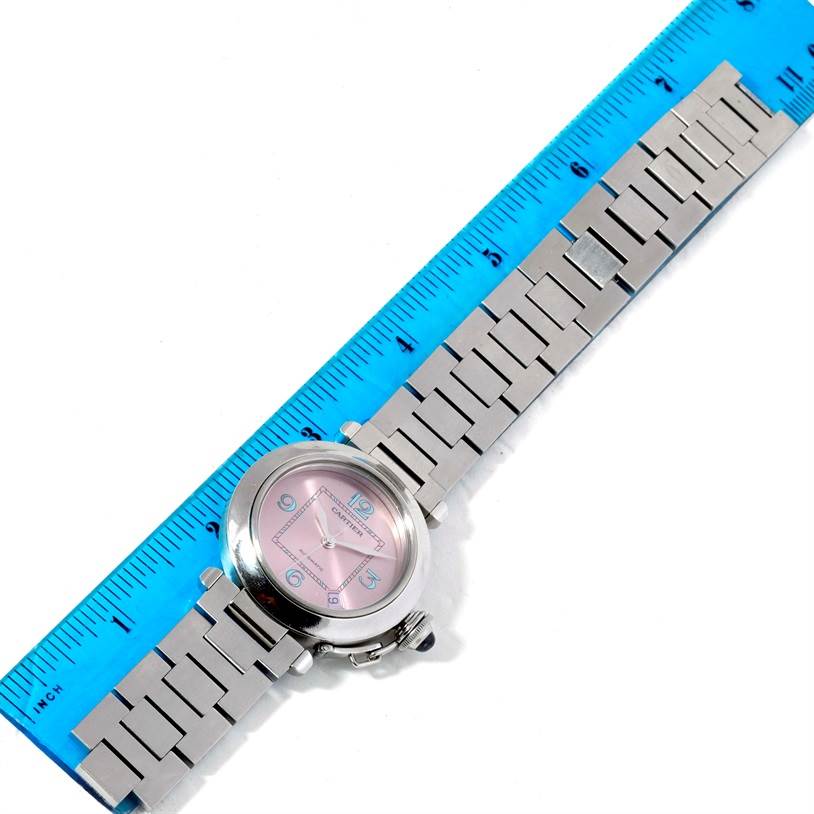 This image shows the Cartier Pasha W3108199 Women's Stainless Steel Pink Dial W3108199 Women's Stainless Steel Pink Dial watch from an overhead angle, displaying its bracelet and face alongside a ruler for measurement.