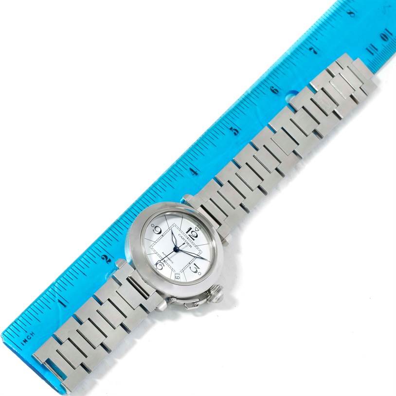 The Cartier Pasha W31074M7 Women's Stainless Steel White Dial W31074M7 Women's Stainless Steel White Dial watch is shown lying flat with a metal bracelet and a blue ruler for scale.