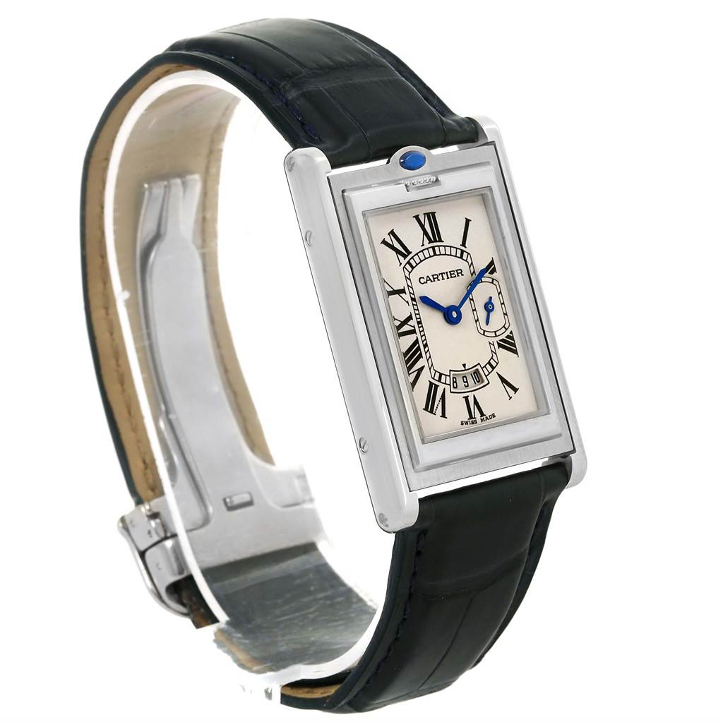 The Tank Basculante by Cartier is shown at an oblique angle, featuring its rectangular dial, leather strap, and side crown with a blue gem.