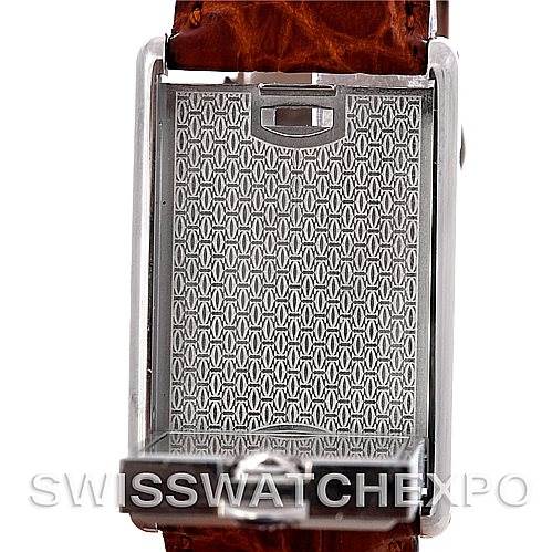 The image shows the back view of a Cartier Tank Basculante Men's Stainless Steel Silver Dial Men's Stainless Steel Silver Dial watch with its case flipped over, revealing the engraved design.