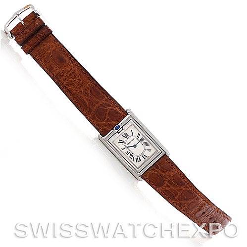 This image shows a top-down view of a Cartier Tank Basculante Men's Stainless Steel Silver Dial Men's Stainless Steel Silver Dial watch with a brown leather strap.