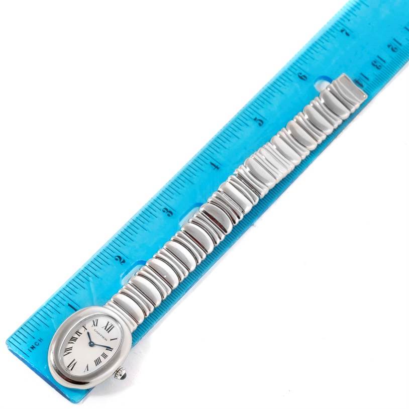 The Cartier Baignoire W15133L2 Women's White Gold Silver Dial W15133L2 Women's White Gold Silver Dial watch is shown from a top-down angle alongside a blue ruler, displaying its face and full metal bracelet.