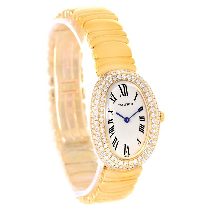 The image shows a Cartier Baignoire 1950 Women
s Yellow Gold Silver Dial 1950 Women
s Yellow Gold Silver Dial watch angled from the front-left, highlighting its oval face, Roman numerals, diamond bezel, and gold bracelet.