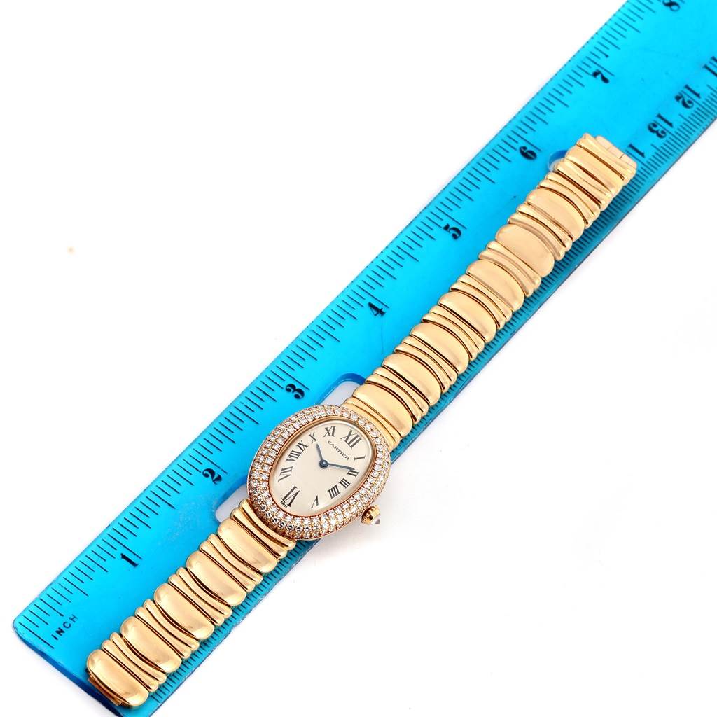 The Cartier Baignoire 1950 Women's Yellow Gold Silver Dial 1950 Women's Yellow Gold Silver Dial watch is shown from a top-down angle, placed next to a blue ruler.