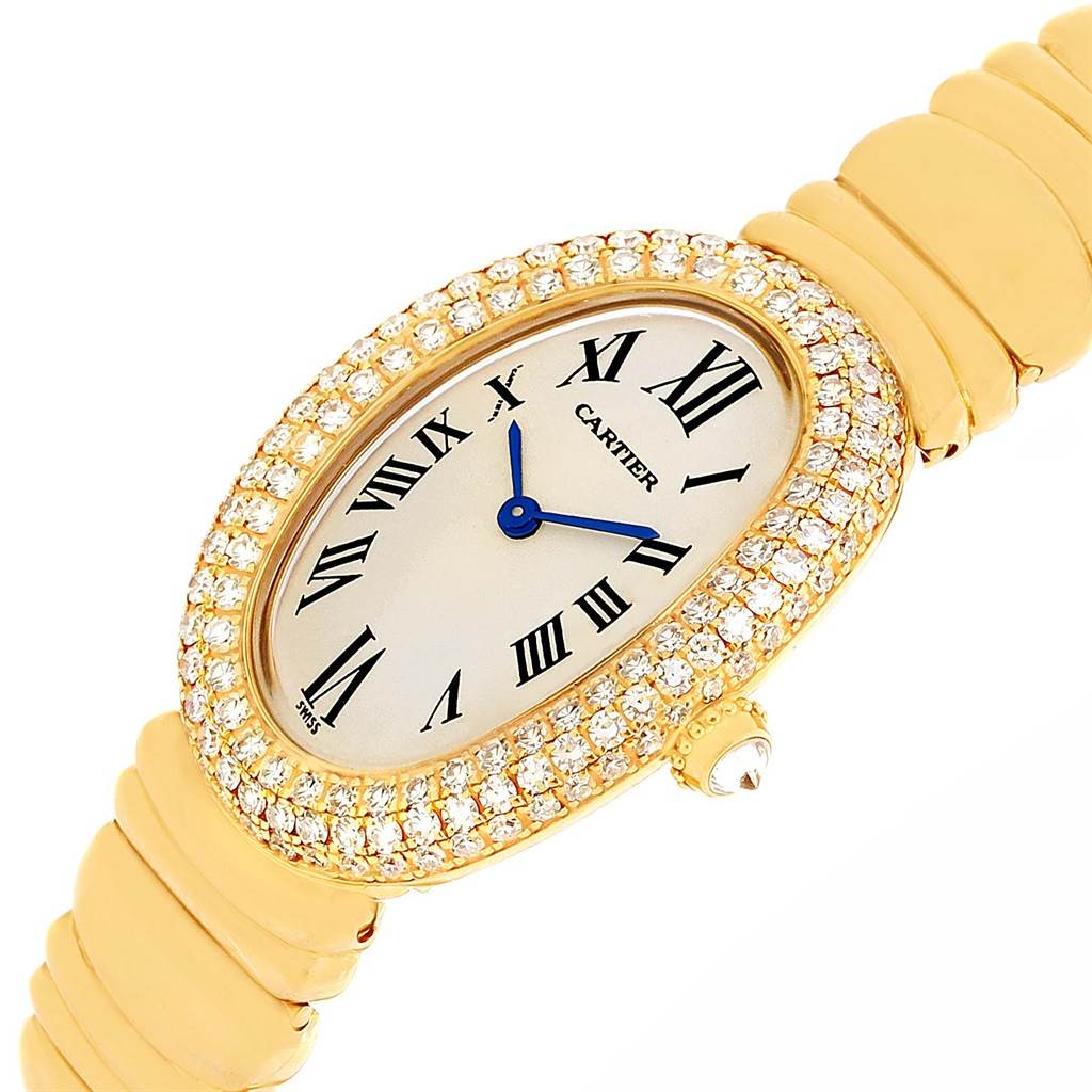 The Cartier Baignoire 1950 Women's Yellow Gold Silver Dial 1950 Women's Yellow Gold Silver Dial watch is shown at an angle, highlighting its diamond-encrusted oval face and gold bracelet.