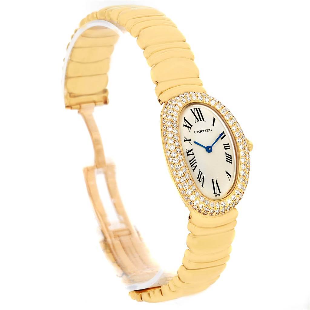 The Cartier Baignoire 1950 Women's Yellow Gold Silver Dial 1950 Women's Yellow Gold Silver Dial watch is shown at an oblique angle, displaying its oval face, gold bracelet, and diamond-encrusted bezel.