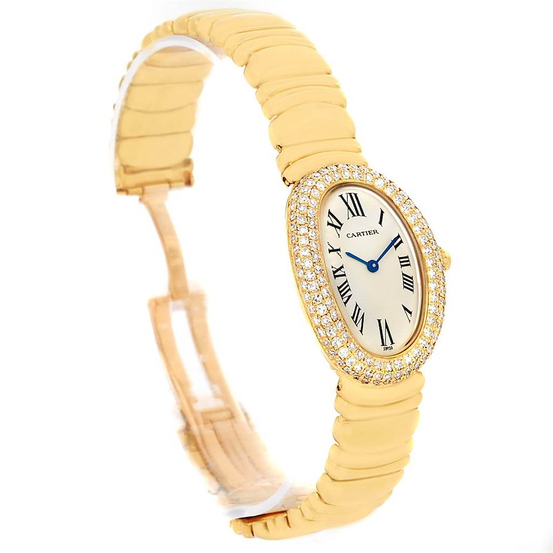 The Cartier Baignoire watch is shown at an oblique angle, displaying its oval face, gold bracelet, and diamond-encrusted bezel.