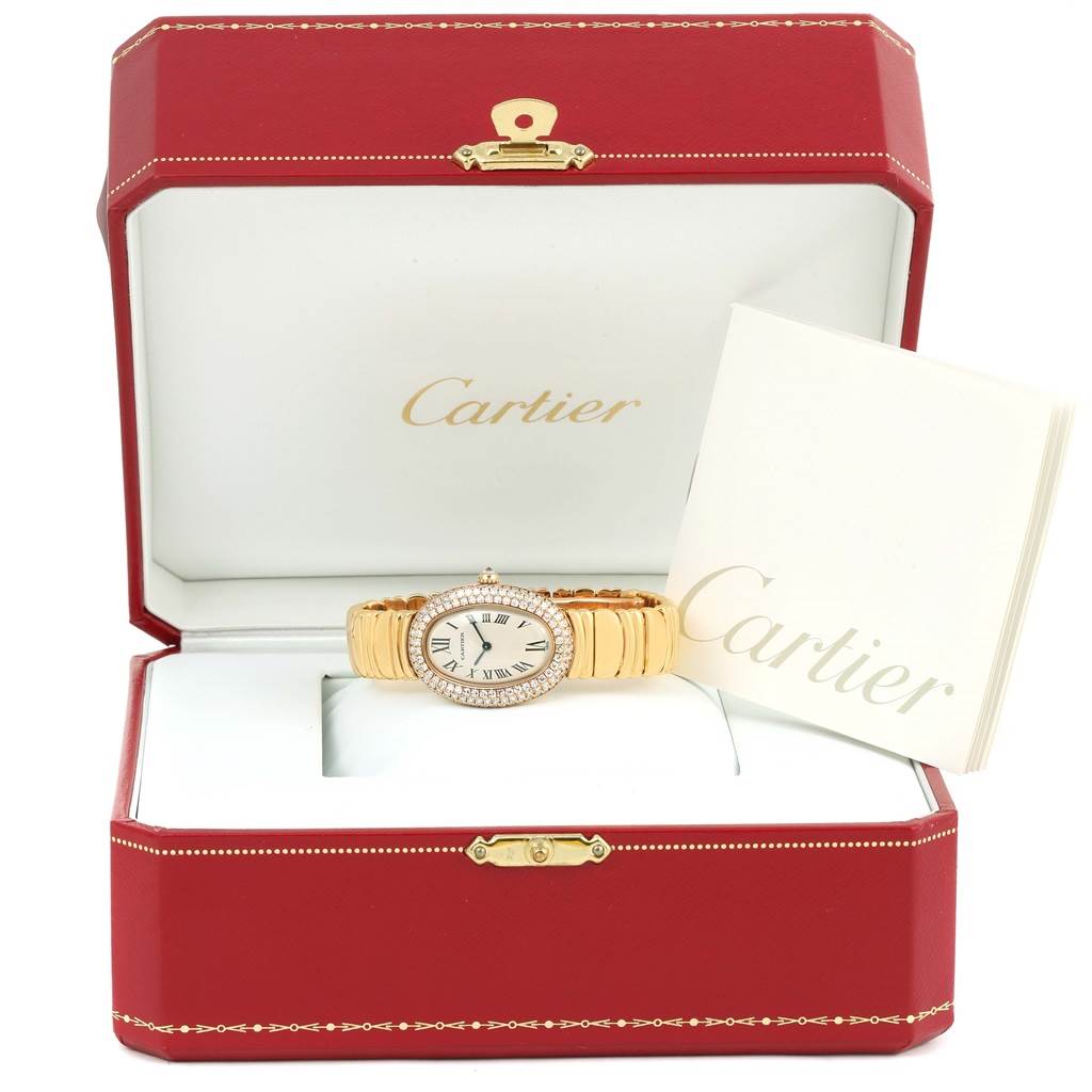The Cartier Baignoire 1950 Women's Yellow Gold Silver Dial 1950 Women's Yellow Gold Silver Dial watch is shown from the front, inside its red box, alongside a booklet.
