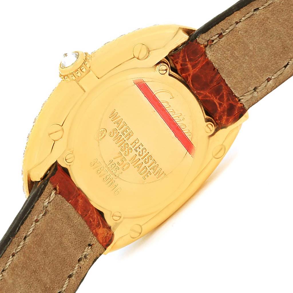 The image shows the back case and part of the leather strap of a Cartier Baignoire 1954 Women
s Yellow Gold Silver Dial 1954 Women
s Yellow Gold Silver Dial watch at an angle.
