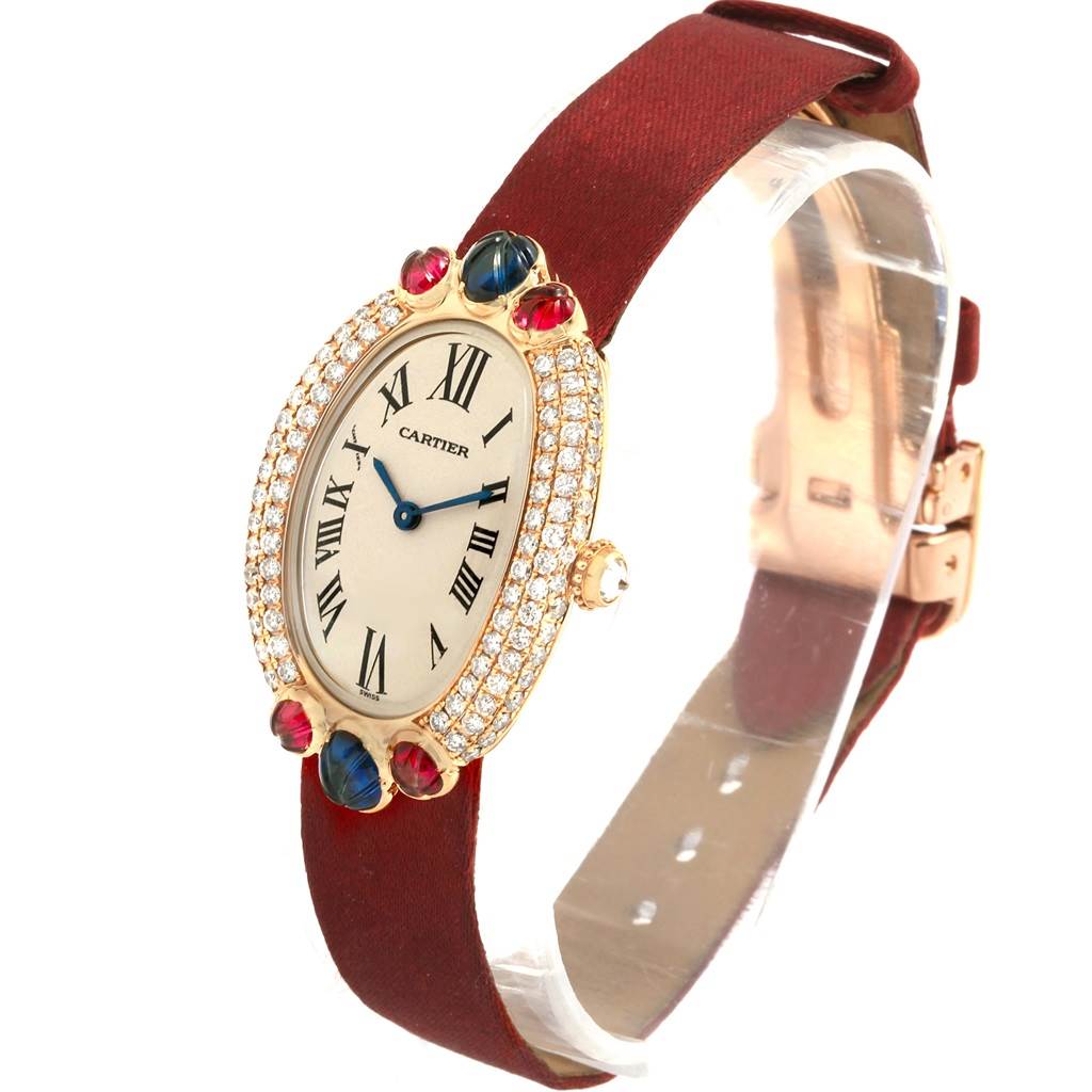 The Cartier Baignoire 1950 Women's Yellow Gold Silver Dial 1950 Women's Yellow Gold Silver Dial watch is shown at an angle highlighting its oval face, diamond bezel, and maroon strap.