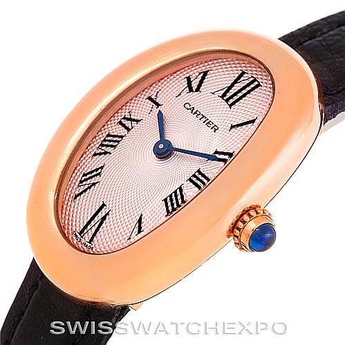 The image shows a side angle of a Cartier Baignoire Women's Rose Gold Pink Dial Women's Rose Gold Pink Dial watch, highlighting its oval face, Roman numerals, and a cabochon-set crown.