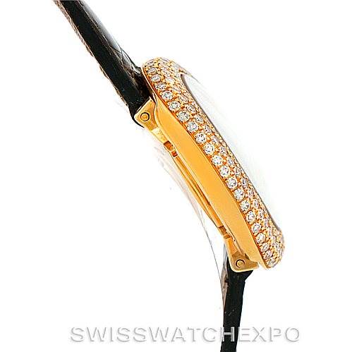 The image shows a side view of the Cartier Baignoire WB501651 Women's Yellow Gold Silver Dial WB501651 Women's Yellow Gold Silver Dial watch, highlighting its diamond-studded bezel and black leather strap.