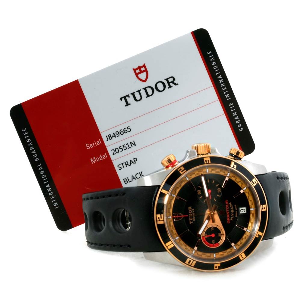 The image shows a Tudor Grantour 20551N Men's Steel and Gold (two tone) Black Dial 20551N Men's Steel and Gold (two tone) Black Dial watch with a black strap and visible side profile, accompanied by a Tudor guarantee card.