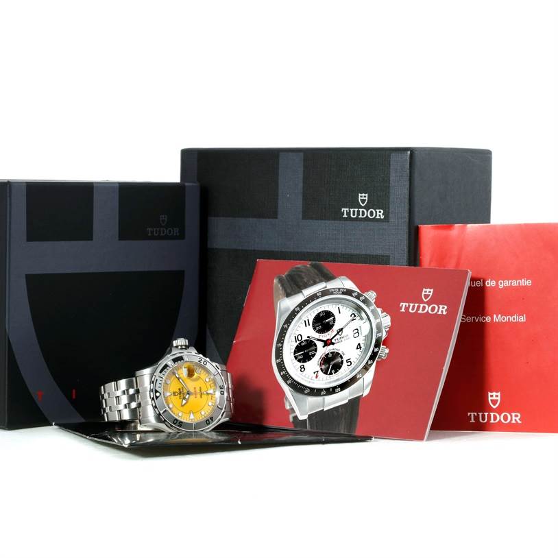 The image shows a Tudor Hydronaut 89190 Men
s Stainless Steel Yellow Dial 89190 Men
s Stainless Steel Yellow Dial watch, a guarantee manual, a service booklet, and the watch
s original box from a side angle.