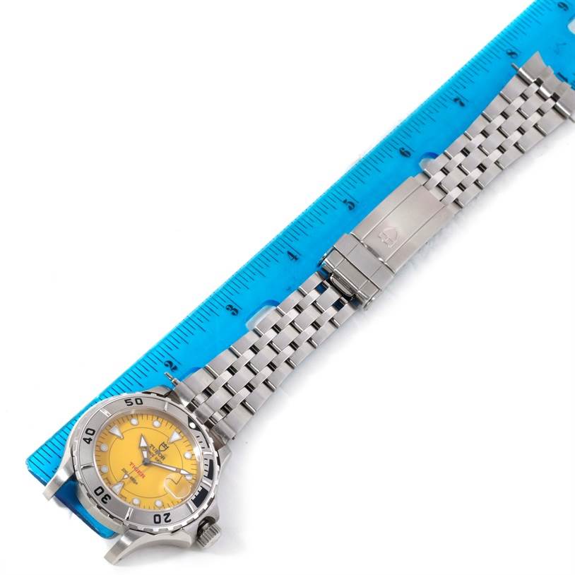The image shows a Tudor Hydronaut 89190 Men
s Stainless Steel Yellow Dial 89190 Men
s Stainless Steel Yellow Dial watch laid flat with its yellow dial and stainless steel bracelet, next to a blue ruler for scale.