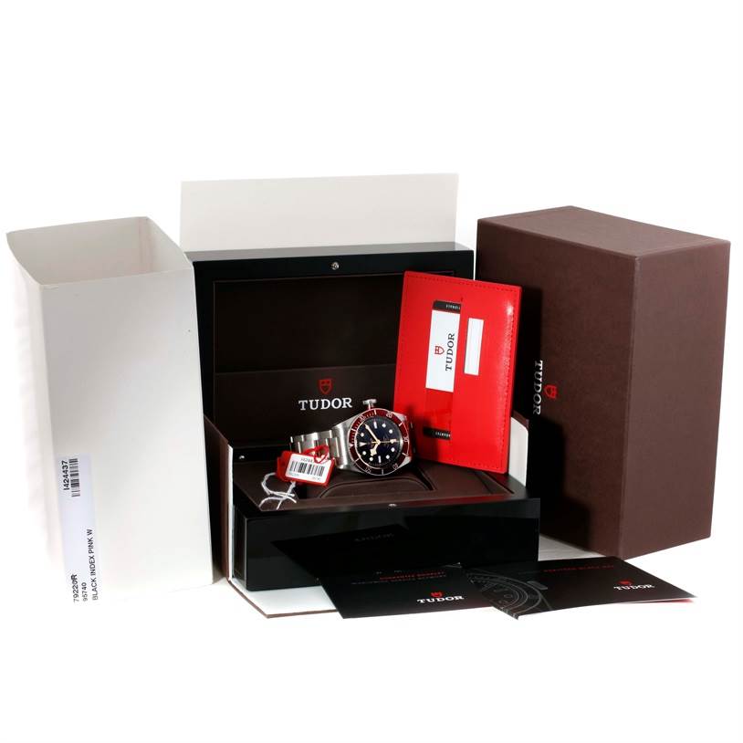 The image shows a Tudor Heritage Black Bay 79220R Men's Stainless Steel Black Dial 79220R Men's Stainless Steel Black Dial watch and its accessories, including the box, manuals, and tags, viewed from the front.