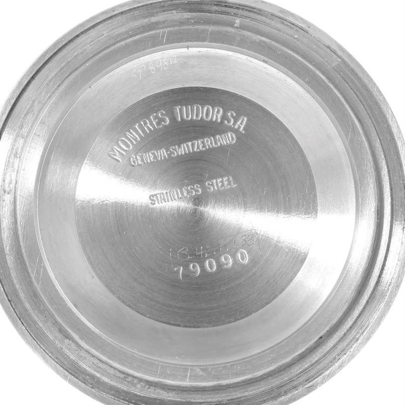 The image shows the inside of the case back of a Tudor Submariner 79090 Men's Stainless Steel Black Dial 79090 Men's Stainless Steel Black Dial watch, displaying engraved details like the brand and model number.