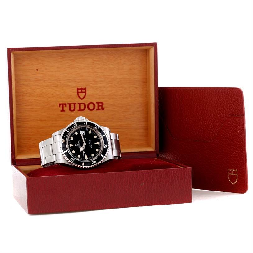The Tudor Submariner 79090 Men's Stainless Steel Black Dial 79090 Men's Stainless Steel Black Dial watch is shown in its open box at a slight angle, accompanied by its branded red leather case.