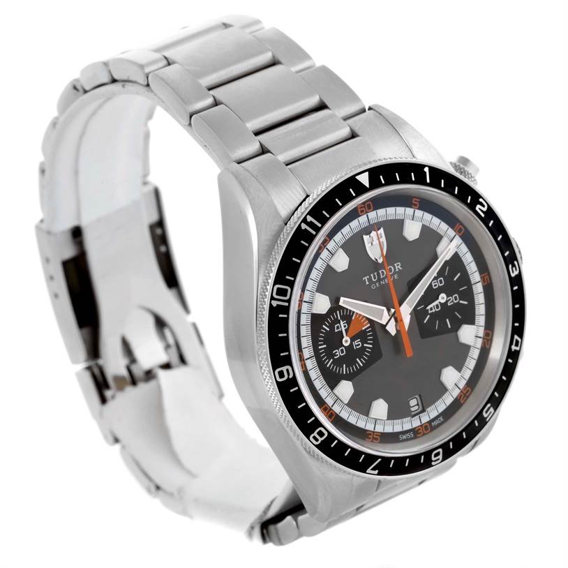 The Heritage Chrono model by Tudor is shown from a side angle, displaying the bracelet, case, bezel, and dial.