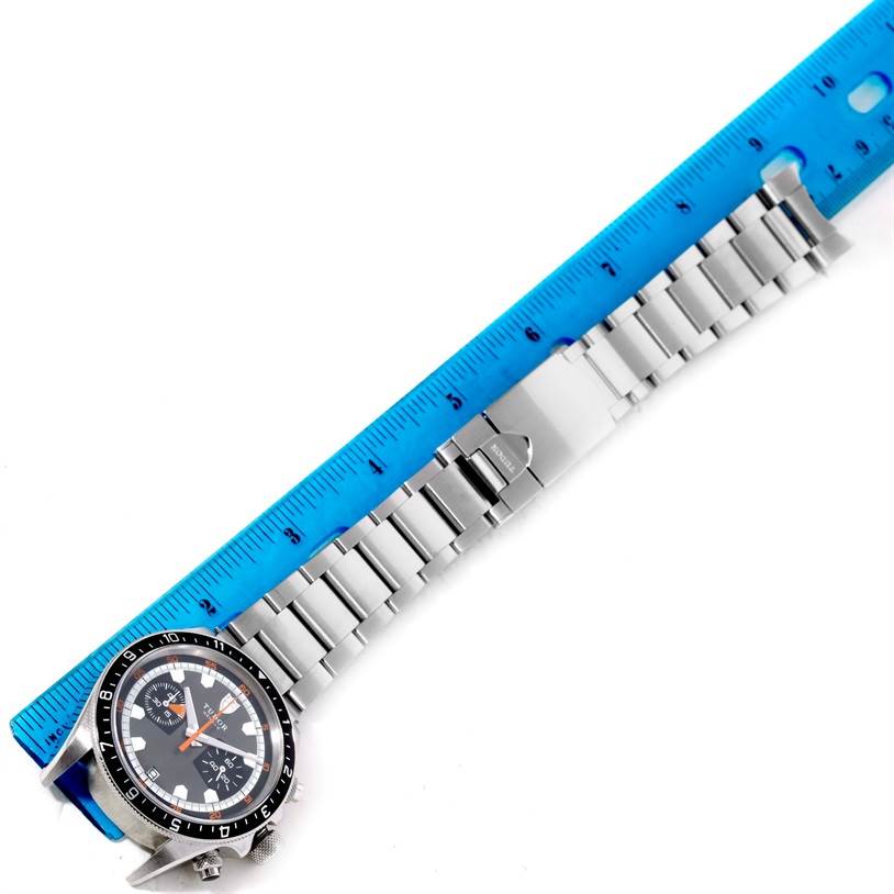 The image shows a Tudor Heritage Chrono 70330N-95740 Men's Stainless Steel Grey Dial 70330N-95740 Men's Stainless Steel Grey Dial watch and its bracelet measured against a blue ruler.