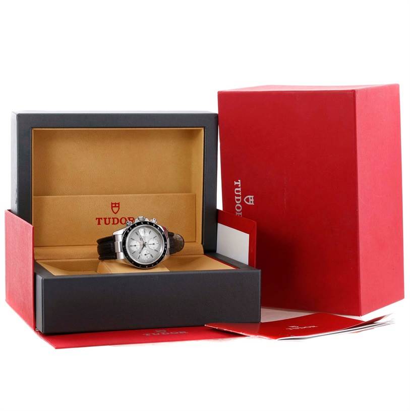 The Tudor Prince watch is displayed at a slight angle within its open box, with additional packaging and booklets beside it.
