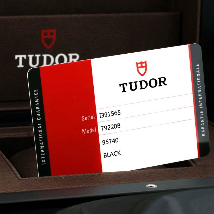 The image shows a warranty card for the Tudor Heritage Black Bay 79220 Men's Stainless Steel Black Dial 79220 Men's Stainless Steel Black Dial watch model with a serial number and model details.
