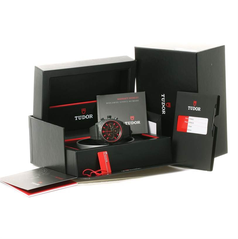 The image shows a Tudor Fastrider 42000CR Men's Stainless Steel Black Dial 42000CR Men's Stainless Steel Black Dial watch and its accessories, including manuals, warranty booklet, card, and packaging, from a front angle.