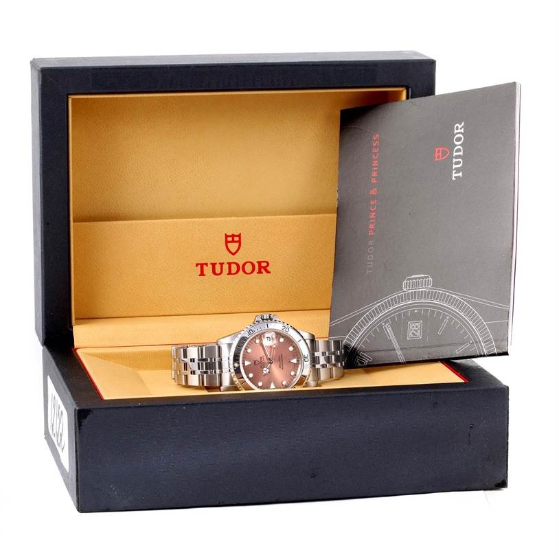 The image shows a Tudor Submariner 75190 Men's Stainless Steel Pink Dial 75190 Men's Stainless Steel Pink Dial watch in its open box with an accompanying booklet.