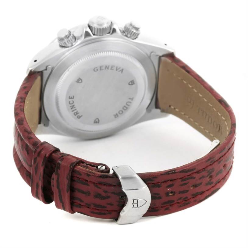 The image shows the back case and crown of the Tudor Tiger 79280 Men's Stainless Steel Burgundy Dial 79280 Men's Stainless Steel Burgundy Dial model watch, along with a red patterned leather strap and buckle.