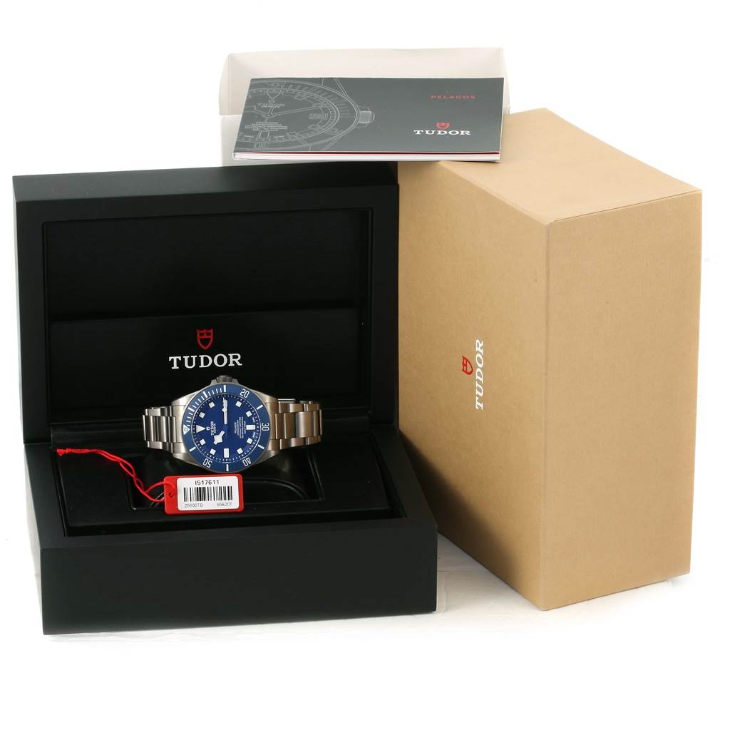 The Tudor Pelagos 25600TB Men's Titanium Blue Dial 25600TB Men's Titanium Blue Dial watch is displayed frontally in an open box, accompanied by its packaging and manual.