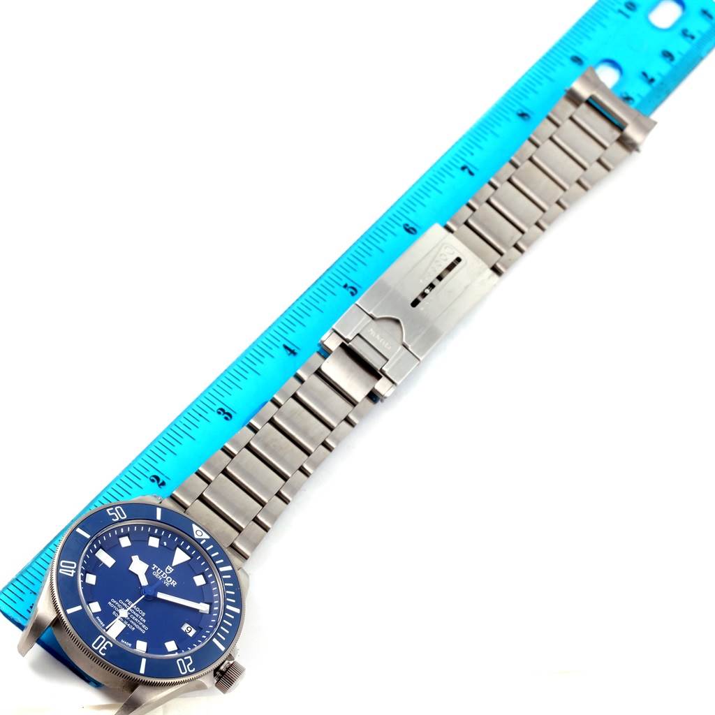The Tudor Pelagos 25600TB Men's Titanium Blue Dial 25600TB Men's Titanium Blue Dial watch is shown from a top view, displaying its face, bezel, and metal bracelet next to a ruler for scale.