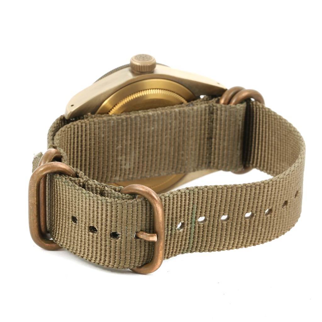 This image shows the back of a Tudor Heritage Black Bay 79250 Men's Bronze Brown Dial 79250 Men's Bronze Brown Dial watch with an olive green fabric strap.