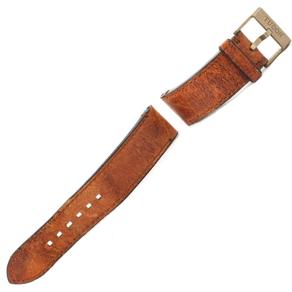 This image shows two separate pieces of the leather strap for a Tudor Heritage Black Bay 79250 Men's Bronze Brown Dial 79250 Men's Bronze Brown Dial watch, including the buckle.