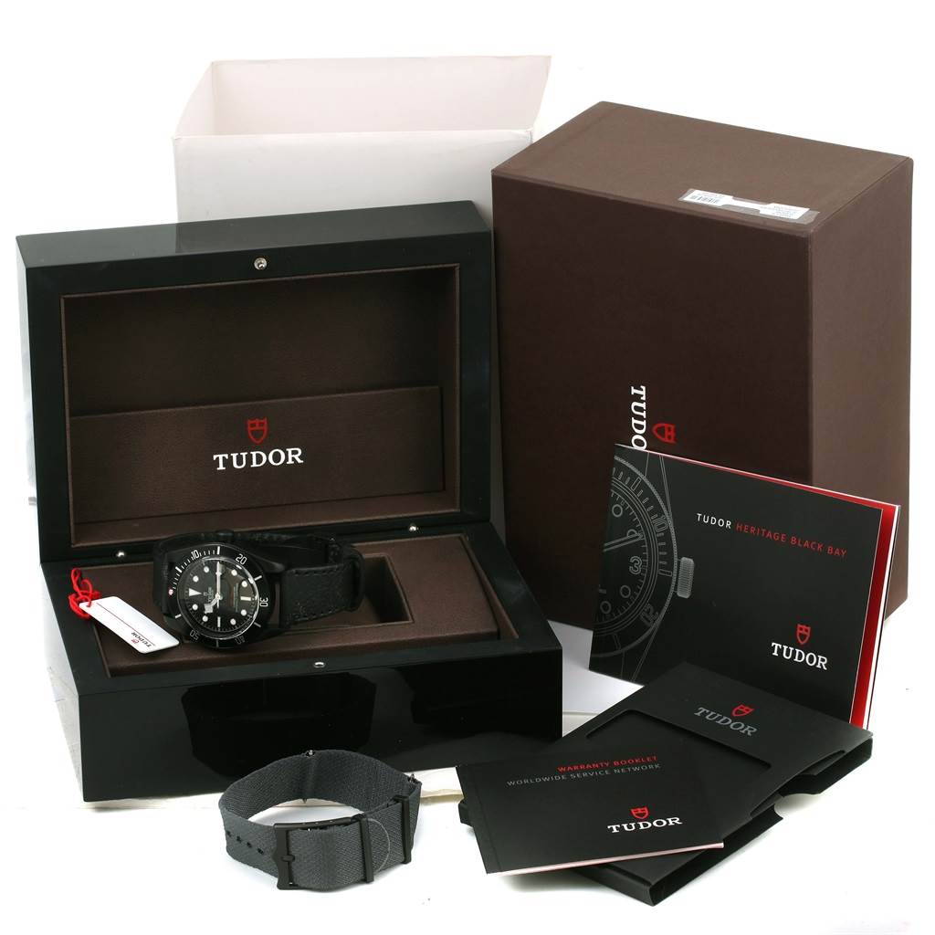 The image shows a Tudor Heritage Black Bay 79230DK Men's Stainless Steel Black Dial 79230DK Men's Stainless Steel Black Dial watch with its open display box, additional strap, booklets, and outer packaging.