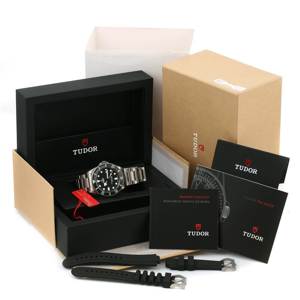 The image shows a Tudor Pelagos 25500TN Men
s Titanium Black Dial 25500TN Men
s Titanium Black Dial watch with its box, manuals, and additional straps.