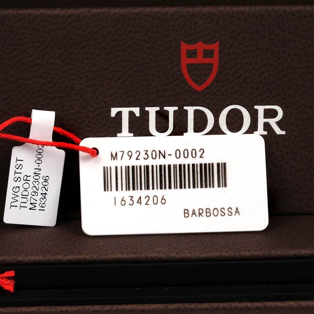 The image shows a close-up of tags with the model number M79230N-0002 for the Tudor Heritage Black Bay 79230N Men's Stainless Steel Black Dial 79230N Men's Stainless Steel Black Dial watch.
