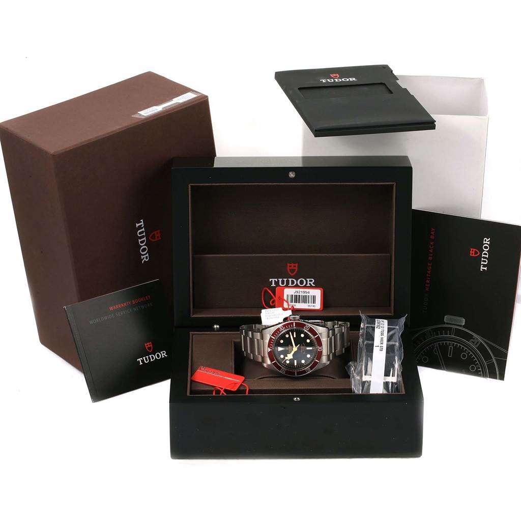 This image shows a Tudor Heritage Black Bay 79220R Men's Stainless Steel Black Dial 79220R Men's Stainless Steel Black Dial watch in its box, accompanied by various accessories and manuals.