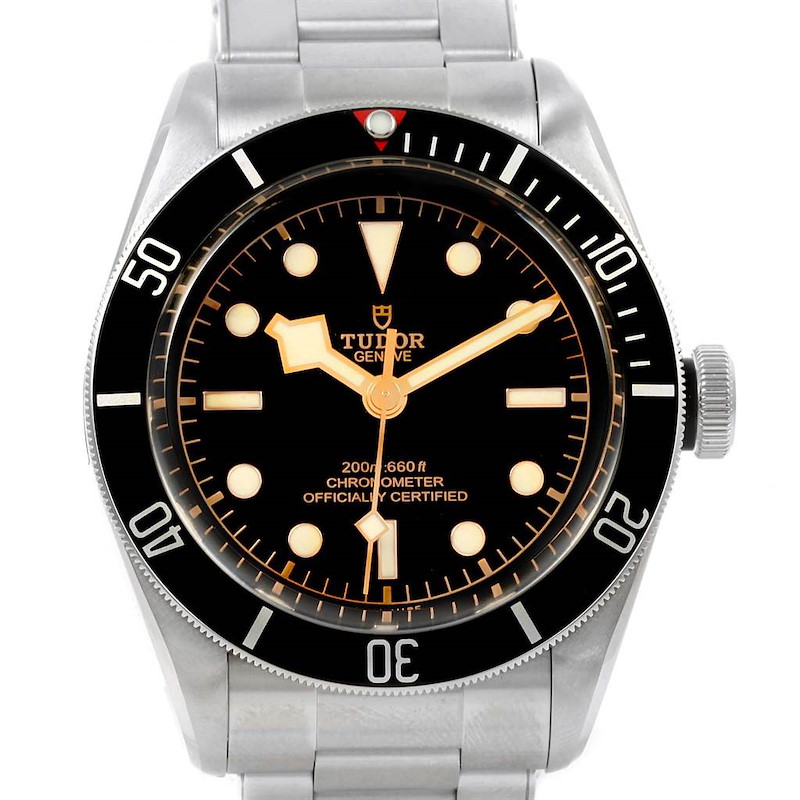 The image shows a front view of the Tudor Heritage Black Bay watch, highlighting its face, bezel, and part of the metal strap.