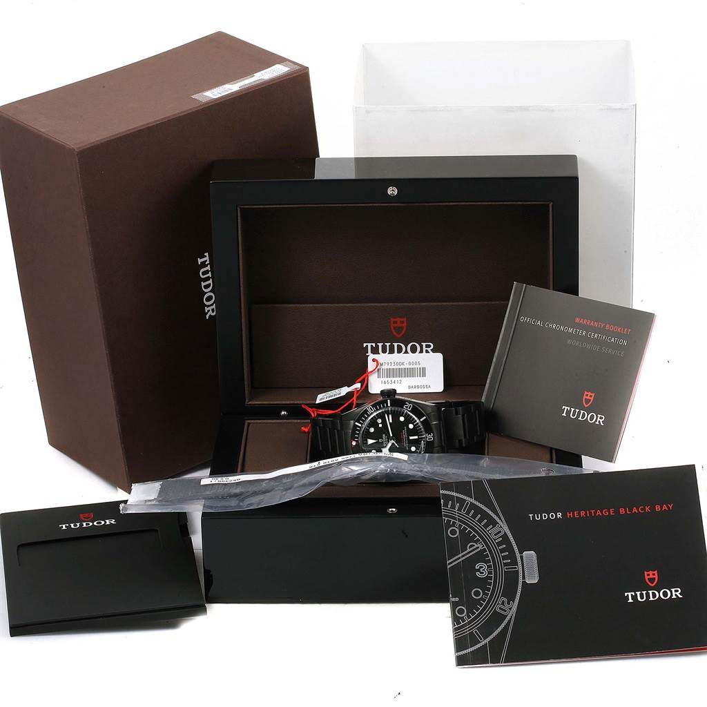 The Tudor Heritage Black Bay 79230DK Men
s Stainless Steel Black Dial 79230DK Men
s Stainless Steel Black Dial watch is shown with its box, warranty booklet, and accessories viewed from an angle in front.