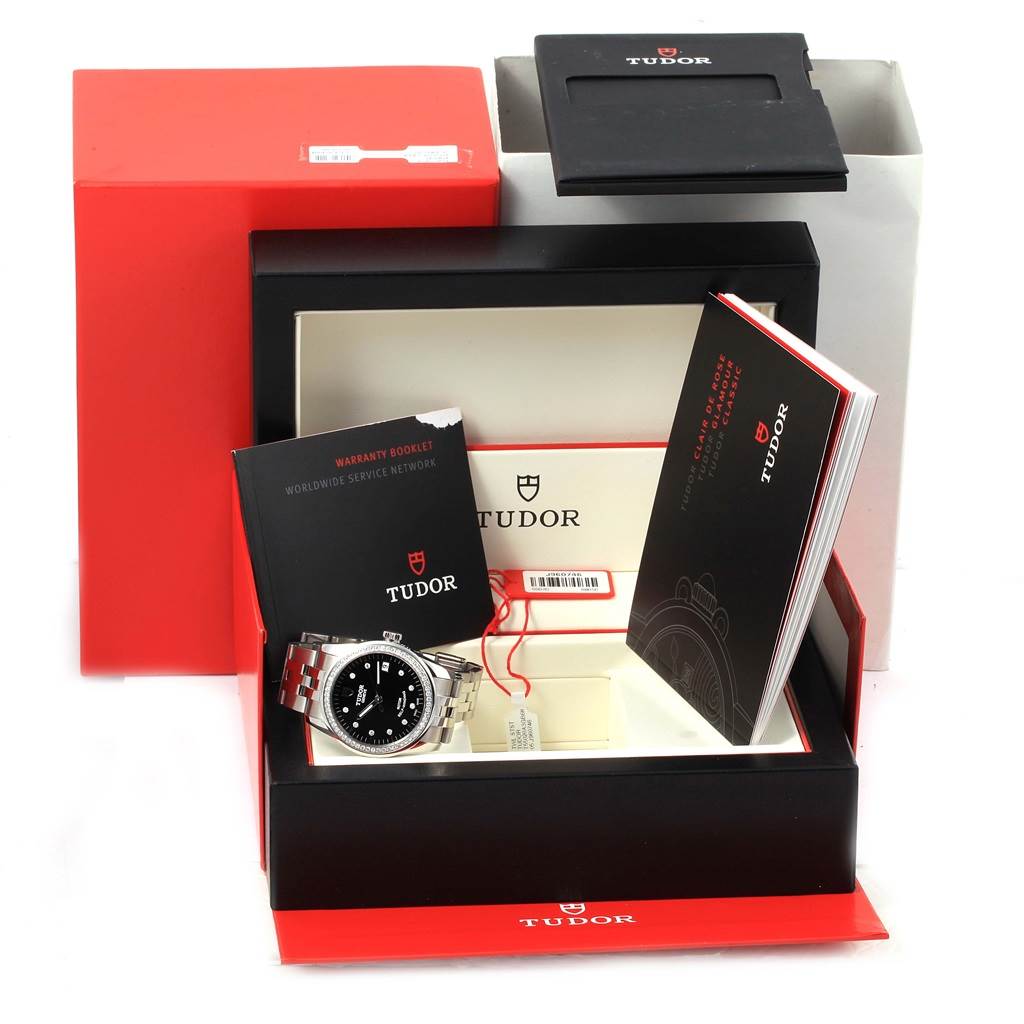 The image shows a Tudor Glamour 55020 Stainless Steel Black Dial 55020 Stainless Steel Black Dial model watch with its original box, warranty booklet, and user manuals.