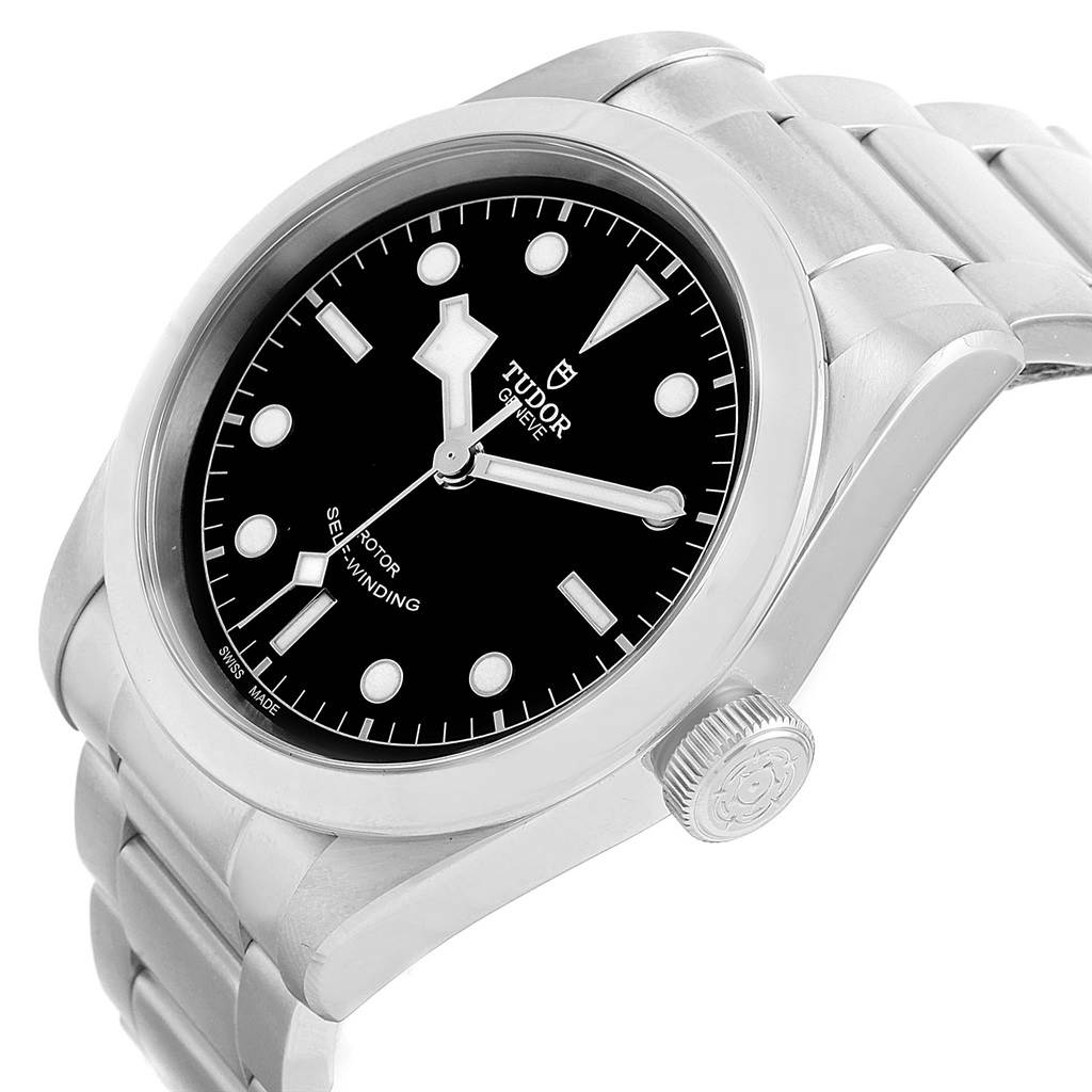 The image shows a Heritage Black Bay watch by Tudor at a three-quarter angle, highlighting the face, bezel, crown, and part of the bracelet.