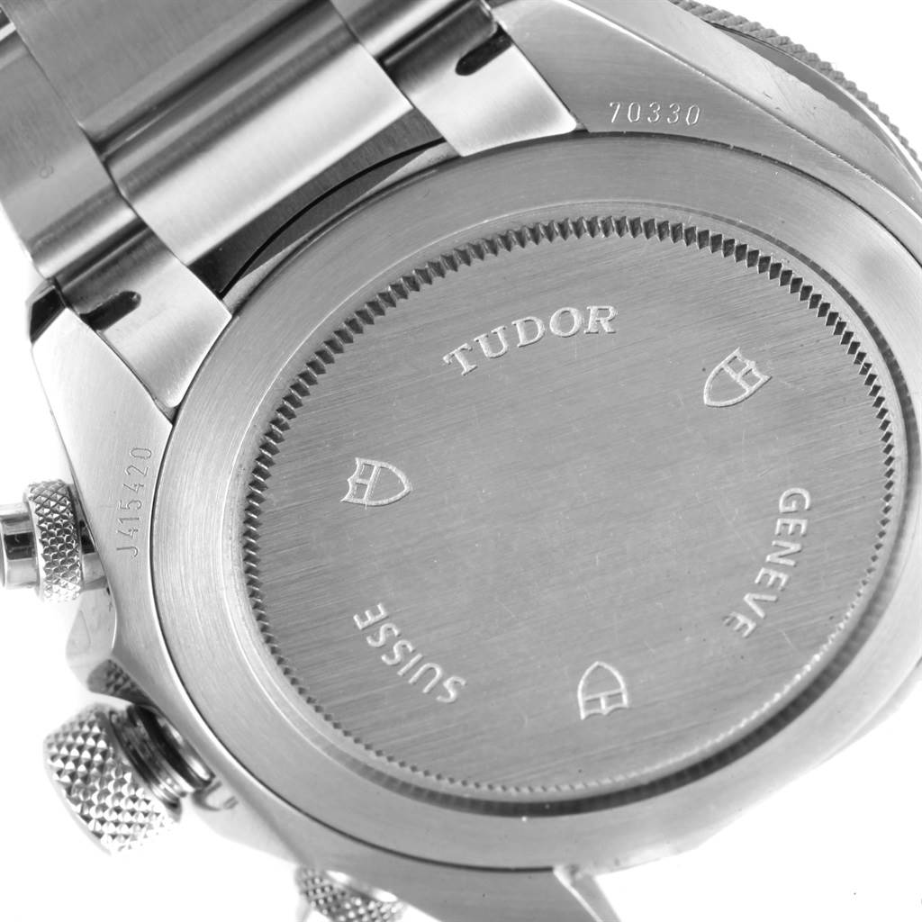 This image shows the back case, lugs, and part of the band of the Tudor Heritage Chrono 70330N Men's Stainless Steel Grey Dial 70330N Men's Stainless Steel Grey Dial watch, featuring engraved branding.