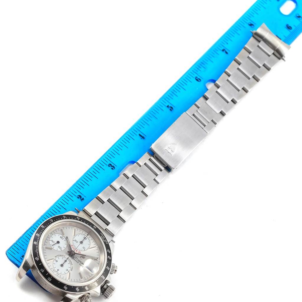 The image shows the Tudor Tiger 79260 Men's Stainless Steel Silver Dial 79260 Men's Stainless Steel Silver Dial watch, displaying its dial, bezel, and metal bracelet alongside a blue ruler.