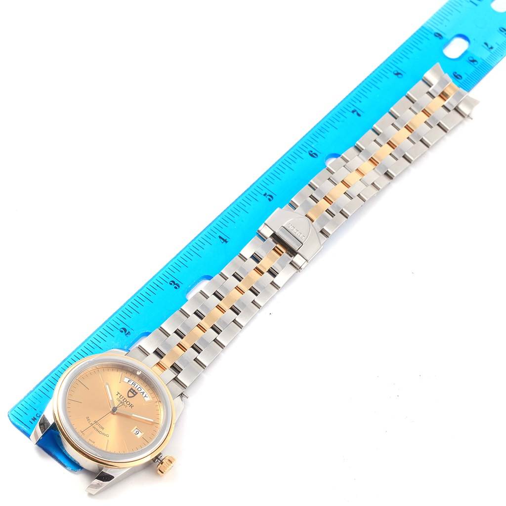 The image shows a Tudor Glamour 56003 Men's Steel and Gold (two tone) Champagne Dial 56003 Men's Steel and Gold (two tone) Champagne Dial watch laid flat next to a ruler, displaying the face, bezel, and bracelet.