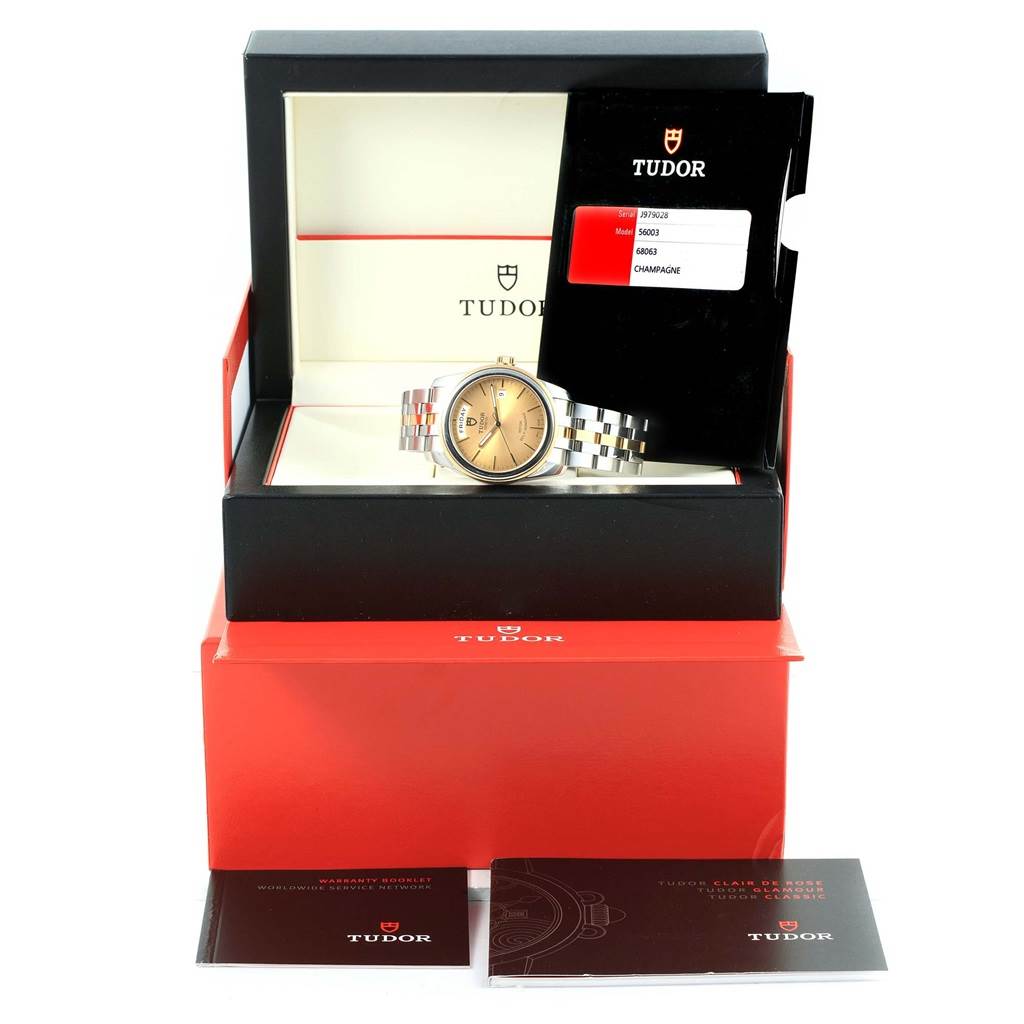 The image shows a Tudor Glamour 56003 Men's Steel and Gold (two tone) Champagne Dial 56003 Men's Steel and Gold (two tone) Champagne Dial watch at an eye-level angle with its box, warranty booklet, and tags.