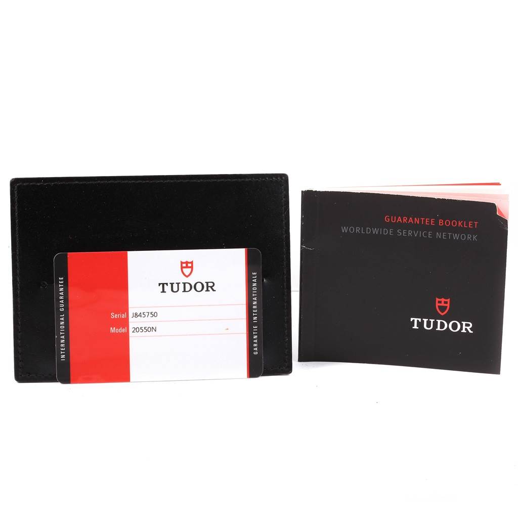 The image shows a guarantee card in a black holder and a service booklet for the Tudor Grantour 20550N Men
s Stainless Steel Black Dial 20550N Men
s Stainless Steel Black Dial watch model.
