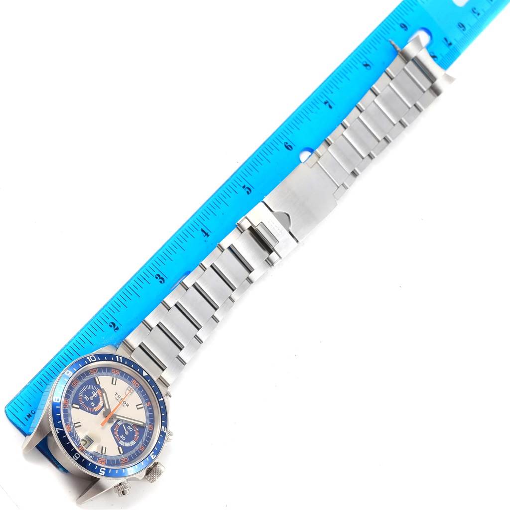 The Tudor Heritage Chrono 70330 Men's Stainless Steel Blue Dial 70330 Men's Stainless Steel Blue Dial watch is shown at an angled top view with its full bracelet and a blue measuring ruler alongside.
