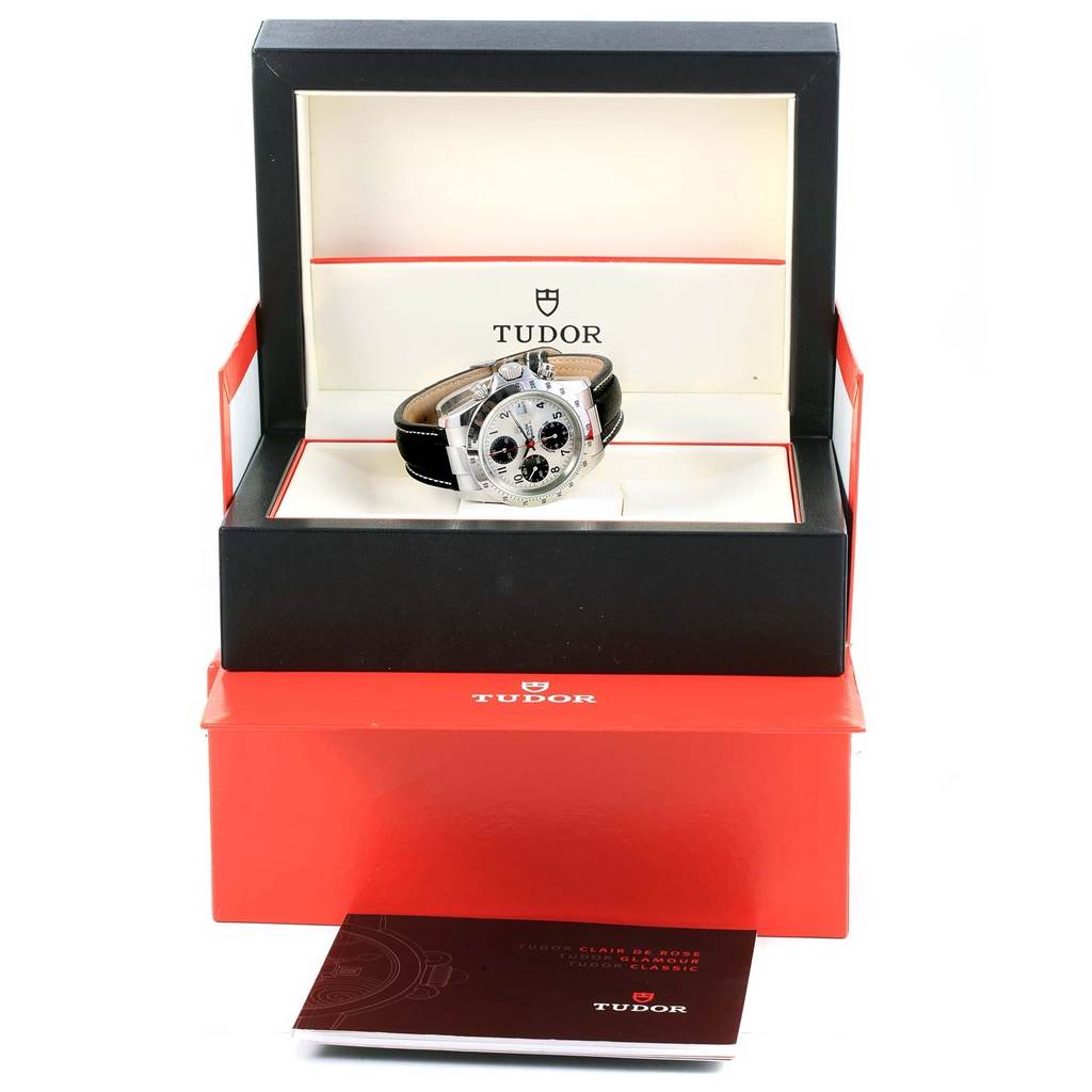 The image shows a Tudor Tiger 79273 Men's Stainless Steel White Dial 79273 Men's Stainless Steel White Dial model watch from a front angle, displayed in its open box with an instruction manual outside.